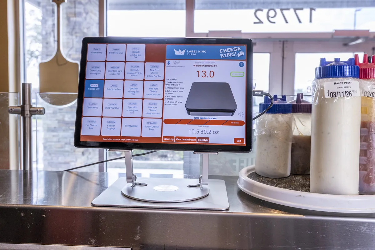 Portion King scale tablet showing a live weight reading next to labeled squeeze bottles